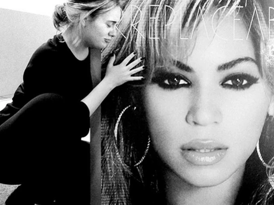 Adele pose devant une affiche de Beyoncé