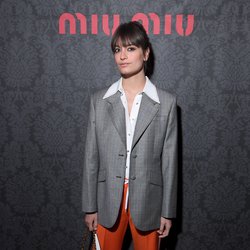 Au défilé Miu Miu, Clara Luciani joue sur les contrastes et les volumes avec une veste de costard oversize et un pantalon à pinces orange.