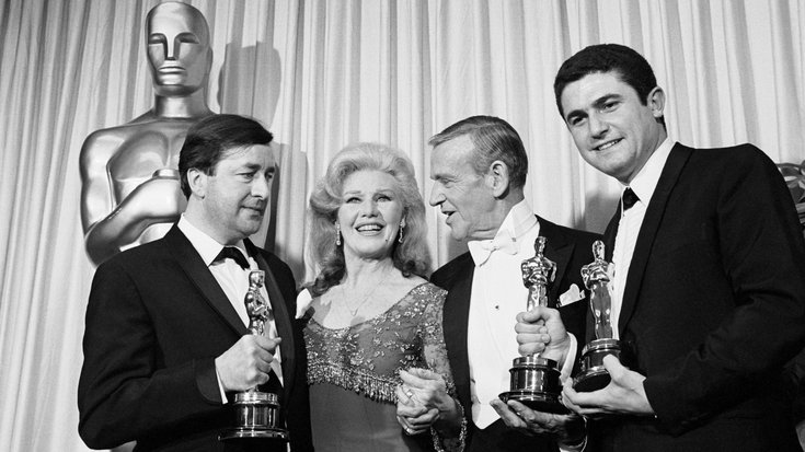 Claude Lelouch tient son Oscar, ainsi que celui de Pierre Uytterhoeven, pour le Meilleur scénario original pour "Un Homme et une Femme" après avoir reçu les récompenses de Ginger Rogers et Fred Astaire. (1967)
